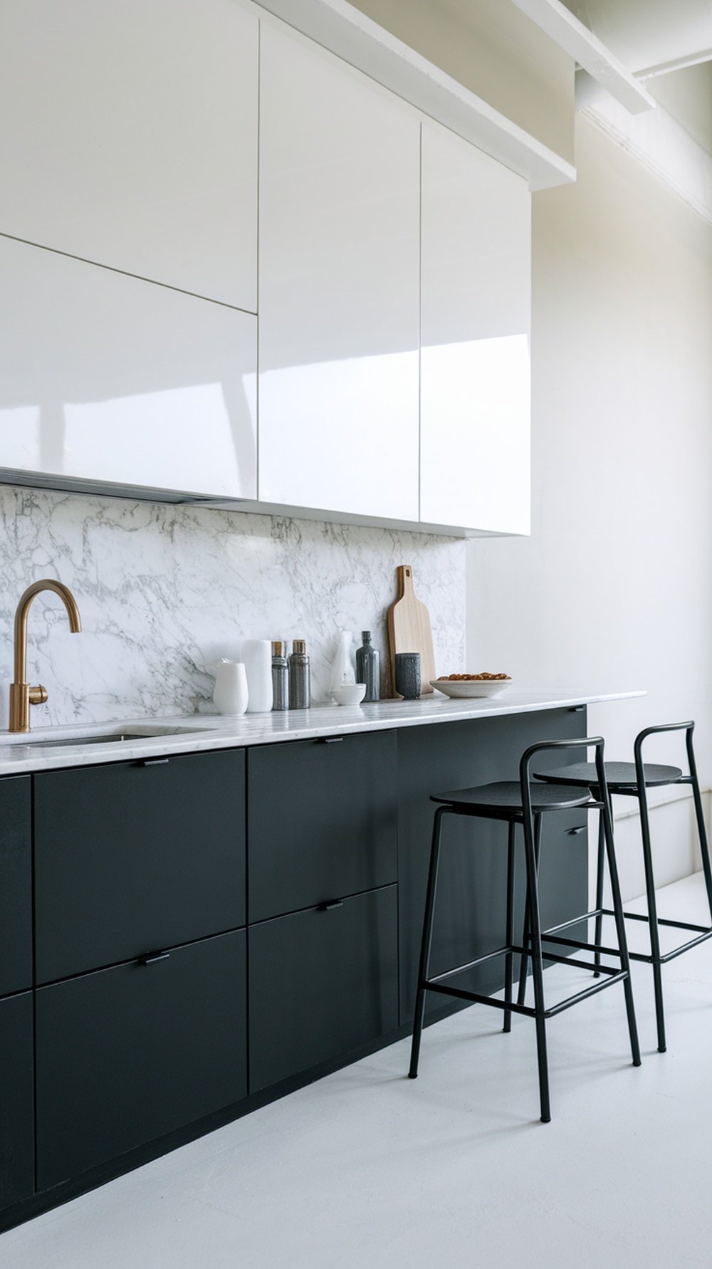 High-contrast mini kitchen featuring black lower cabinets and glossy white upper cabinets with a marble backsplash.