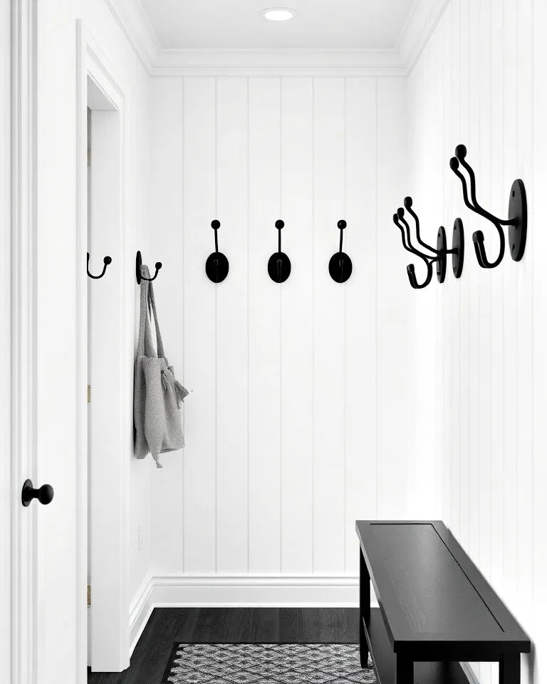 black wall hooks on white hallway walls